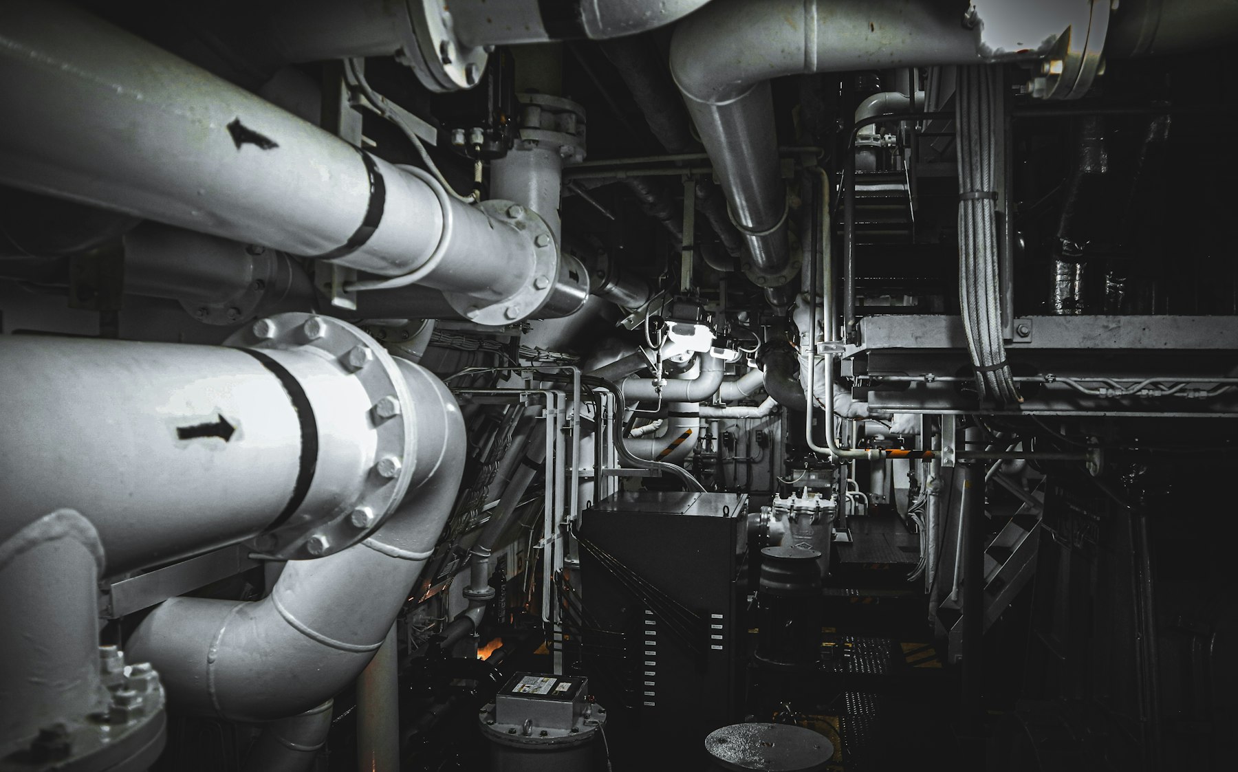 Flanged pipes and cable trays in a dark machinery space